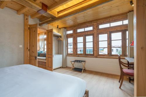 une chambre avec un lit, un bureau et des fenêtres dans l'établissement Casona Azul Llue - Asturias Vacations, à Colunga