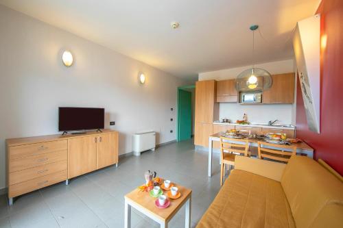 un salon avec un canapé et une cuisine dans l'établissement Villaggio Olimpico, à Sestrières