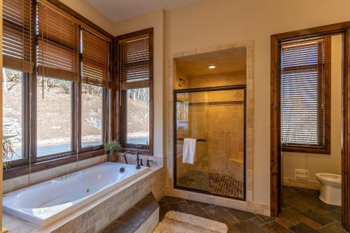 bagno con vasca, doccia e finestre di Banner Crest a Banner Elk