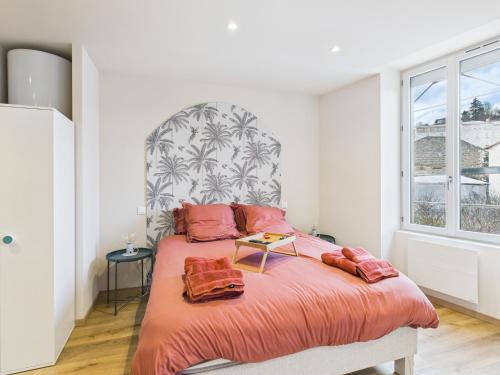 a bedroom with a large bed with two pillows on it at La petite suite Ponote in Le Puy en Velay