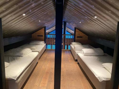 three beds in a room with a wooden ceiling at Villa Hulu in Broaryd