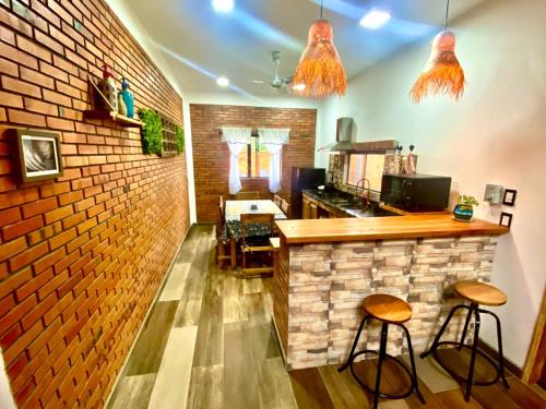 un bar con dos taburetes y una pared de ladrillo en Cabaña Premium Ñakurutu de La Mala Junta, en Atyrá