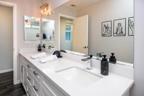 a bathroom with two sinks and a large mirror at #Marbella Lane - Desert Dream Pool Spa & Games in Desert Hot Springs