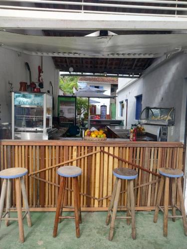 un comptoir avec trois tabourets devant une cuisine dans l'établissement Pousada Dádiva Lirío Encantado a passos da Praia do Pontal e Centro, à Parati