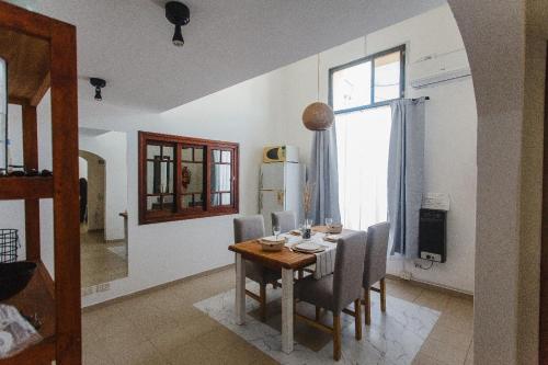 a dining room with a table and chairs and a window at Almablanca in San Antonio de Areco