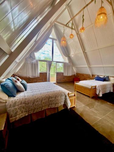a bedroom with two beds in a attic at Cabaña Premium Ñakurutu de La Mala Junta in Atyrá