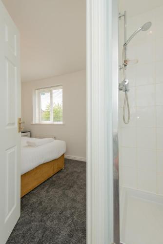 a bedroom with a bed and a window and a shower at Thinford View 4 bed, 2bath, Parking, Garage in Spennymoor