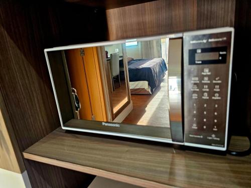 累西腓Valor Imbatível ! Flat Frente Mar com Enxoval completo的微波炉,放在一个房间里台面上