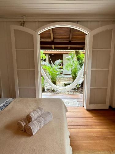 a room with a mirror and two rolled towels on a bed at Pousadinha in Ilha do Mel