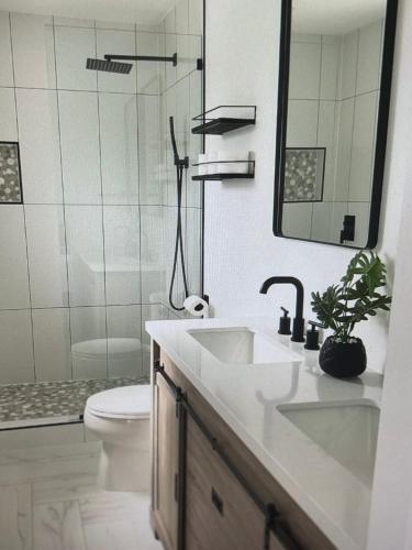 a bathroom with a sink and a toilet and a mirror at Tropical Bliss in George Town