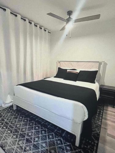 a bedroom with a white bed with black pillows at Tropical Bliss in George Town