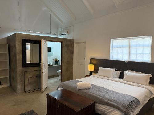 Un dormitorio con una cama grande y un baño. en Regalia Suites, en Kraaifontein