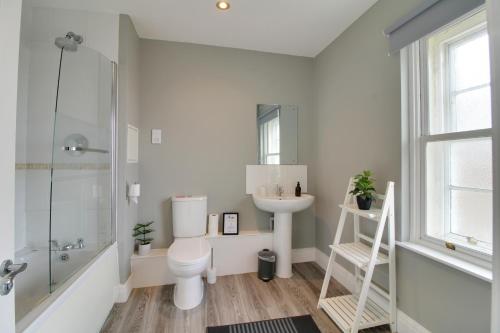a bathroom with a toilet and a sink and a shower at Penthouse Parade Apartment, Sleeps 6 in Harrogate