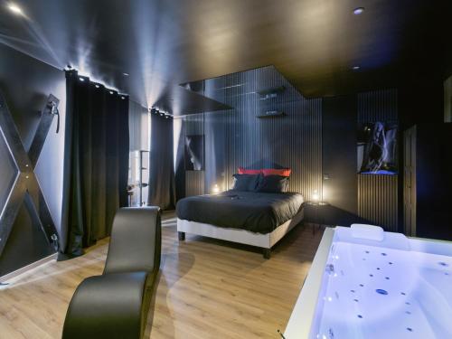 a bedroom with a bed and a tub in it at Cinquante Nuances Ponotes in Le Puy-en-Velay
