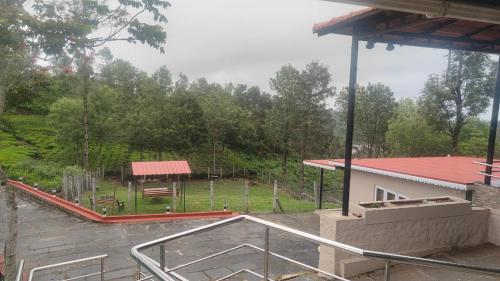 a view of a park with a bench and a building at Blue Nile Homestay Kotagiri in Kotagiri