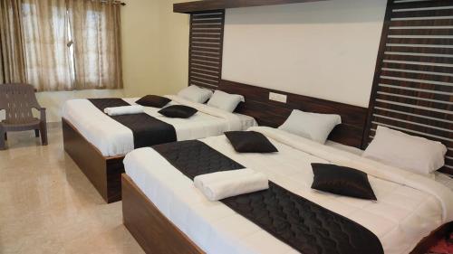 a bedroom with two beds and a chair in it at Blue Nile Homestay Kotagiri in Kotagiri