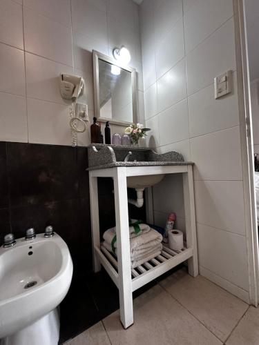 ein Badezimmer mit Waschbecken, Toilette und Spiegel in der Unterkunft En el Corazón de Salta in Salta