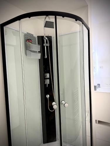 a glass shower door with a mirror in a room at Écrin de Roye in Roye
