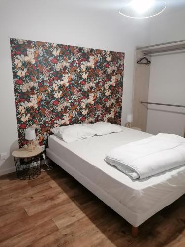 una camera da letto con un letto grande con testiera floreale di Étape Douessine a Doué-la-Fontaine