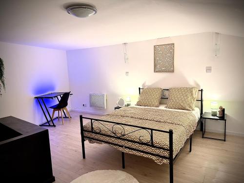 une chambre avec un lit et une table dans une pièce dans l'établissement Écrin de Roye, à Roye