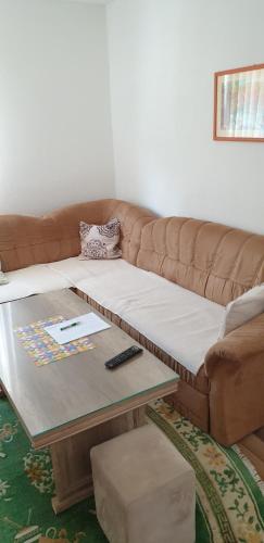 a brown couch with a coffee table in a living room at Daily rental apartment Travnik in Travnik