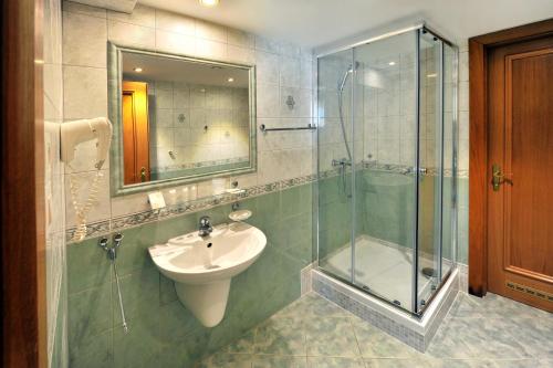 a bathroom with a sink and a glass shower at APLEND CITY Hotel Perugia in Bratislava