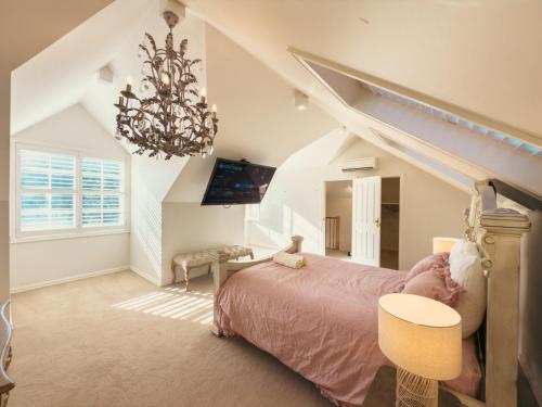 una camera da letto con un letto e un lampadario di Pudding's Home Puffing Billy Dandenong Mountain View Retreat a Upwey