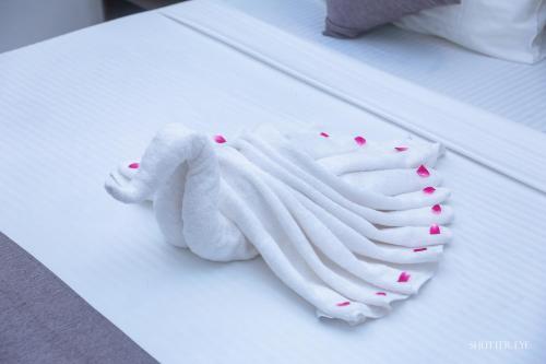 ein weißes Handtuch mit rosa Herzen auf einem Tisch in der Unterkunft Zeyora Mirissa in Mirissa