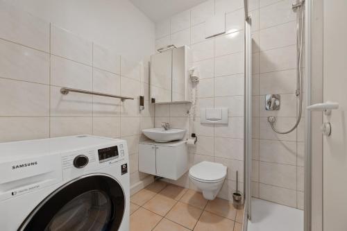 a washing machine in a bathroom with a toilet and a sink at RANGE - 2 Apartments - Küche - WLAN - Netflix - Balkon - 1-6 Personen in Fellbach