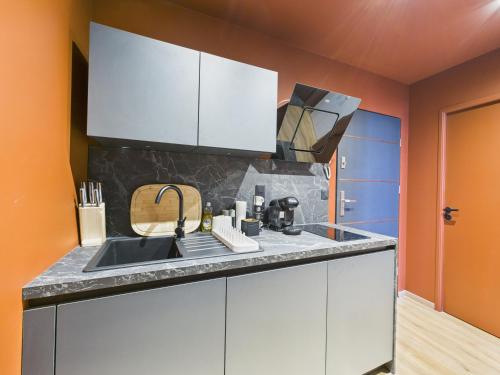 a kitchen with white cabinets and a sink at Ciné-Ponot in Le Puy en Velay