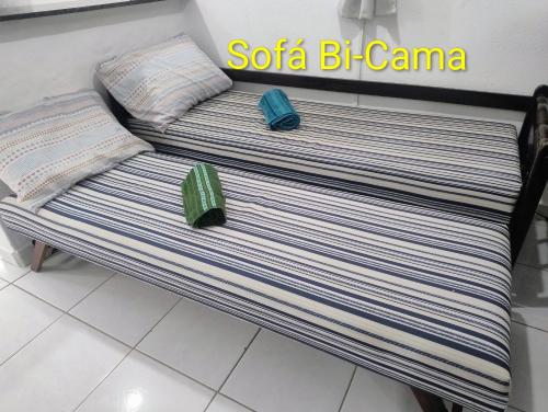 a bench in a store with two pillows on it at Espaço inteiro-Praia de Barequeçaba - São Sebastião -SP in São Sebastião