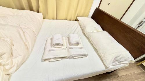 a bed with white sheets and pillows on it at Good One Awaji Accessia 401 in Osaka