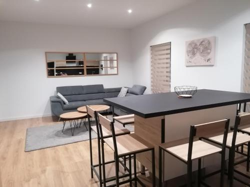 a living room with a couch and a table and chairs at Étape Douessine in Doué-la-Fontaine