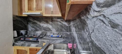 a kitchen with a sink and a counter top at EJ Cozy Transient in Baguio in Tuba