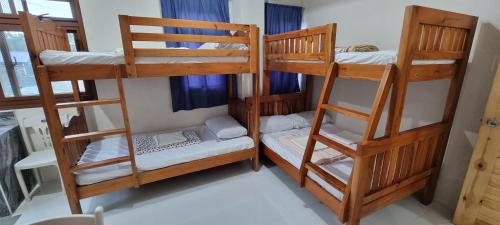 a room with three bunk beds in a house at EJ Cozy Transient in Baguio in Tuba