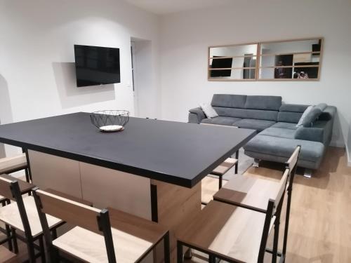 a living room with a table and a couch at Étape Douessine in Doué-la-Fontaine
