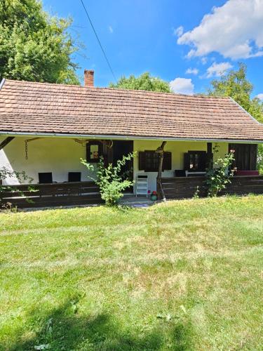 a small yellow house with a grass yard at Birsalmafa Vendégház in Bajánsenye
