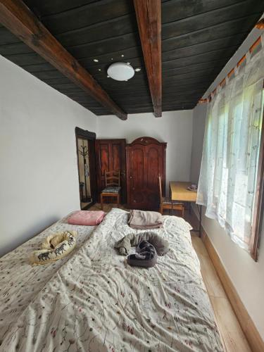 a bedroom with a large bed and a wooden ceiling at Birsalmafa Vendégház in Bajánsenye