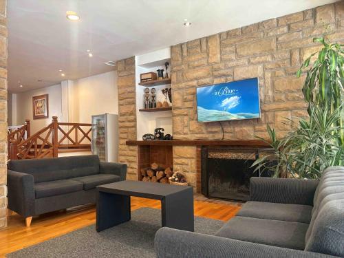 ein Wohnzimmer mit zwei Sofas und einem Kamin in der Unterkunft Rosa de los Viajes in San Martín de los Andes