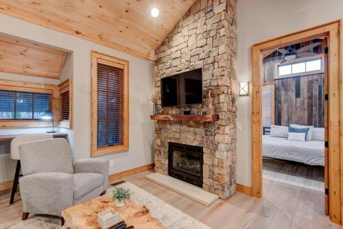 a living room with a stone fireplace and a tv at Banner Bear in Banner Elk