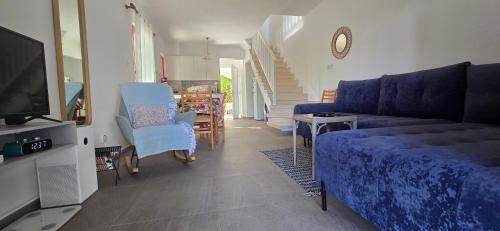 a living room with a couch and a tv at Barefoot Beach House in Larnaca