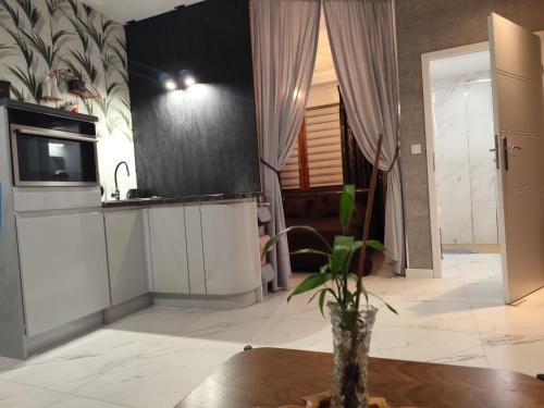 a kitchen with a table and a vase on a table at Somewhere Between Apartments in Piechowice