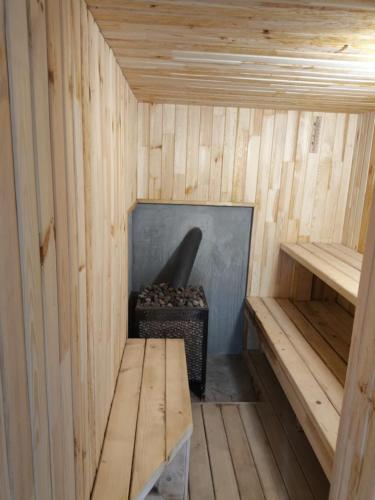a sauna with a bench and a stove in it at Cabana de lemn Lacul Bicaz in Hangul