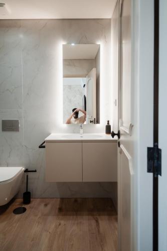 a person taking a picture of a bathroom sink at Rua Fraga - Os Maias in Vila do Conde