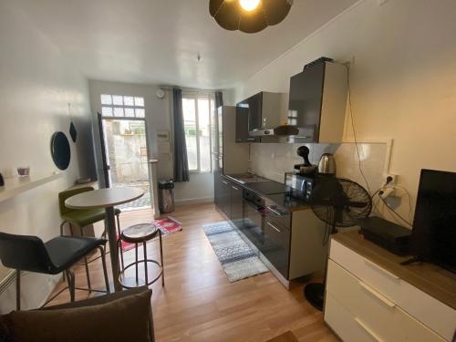 eine Küche mit einer Theke, einem Tisch und Stühlen in der Unterkunft Le charles in Paris