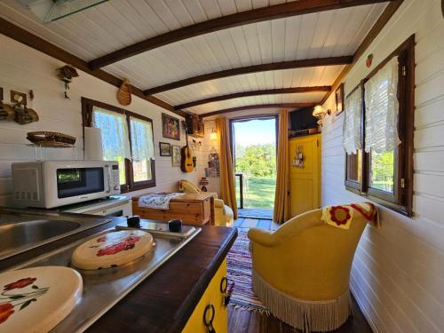 eine Küche und ein Wohnzimmer eines winzigen Hauses in der Unterkunft Roulotte Belle des Prés in Sigalens