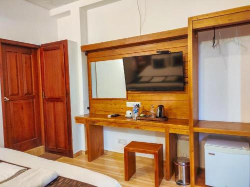 Habitación con TV en la pared y mesa. en Kandy Krush Hostel, en Kandy