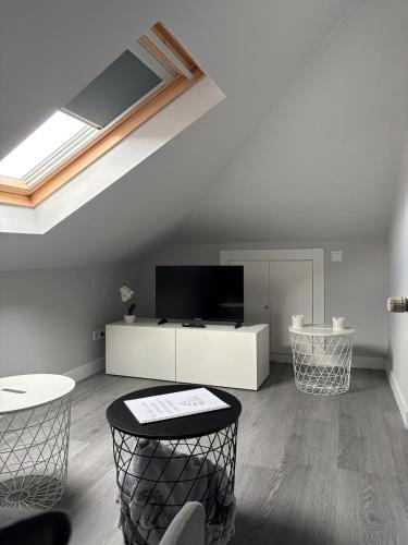 桑坦德Ático recién reformado en Santander的客厅里有天窗、两张桌子和一台电视