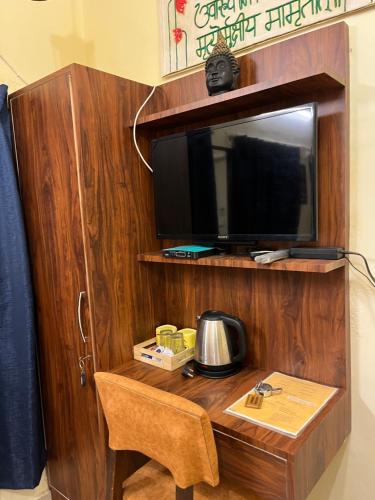 una habitación con un escritorio con televisión y una silla en Kailash Heritage Homestay, en Varanasi