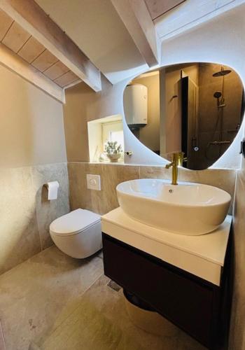 a bathroom with a sink and a toilet and a mirror at L'Atelier TOP LOCATION in Corfu
